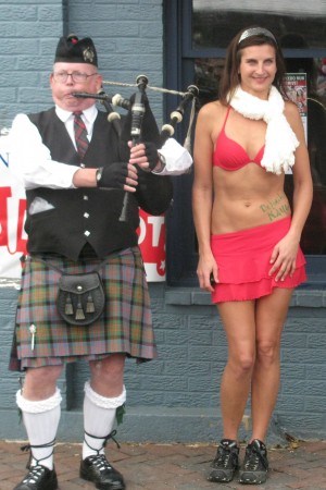 Miss Claus and a bagpiper at the Santa Speedo Run In Annapolis
